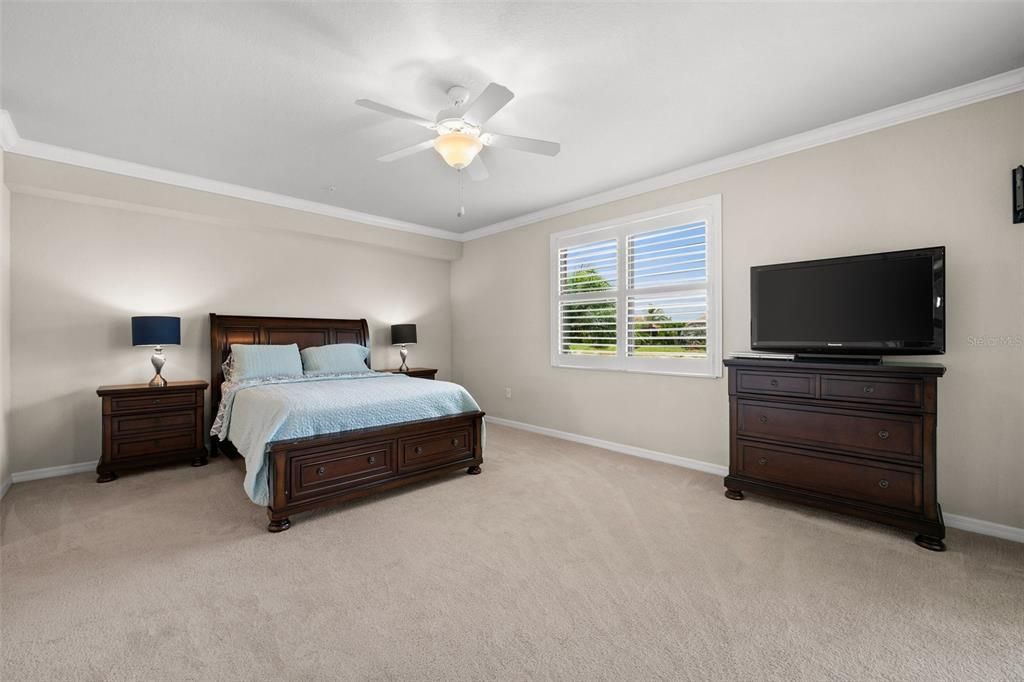 Spacious primary bedroom with crown molding