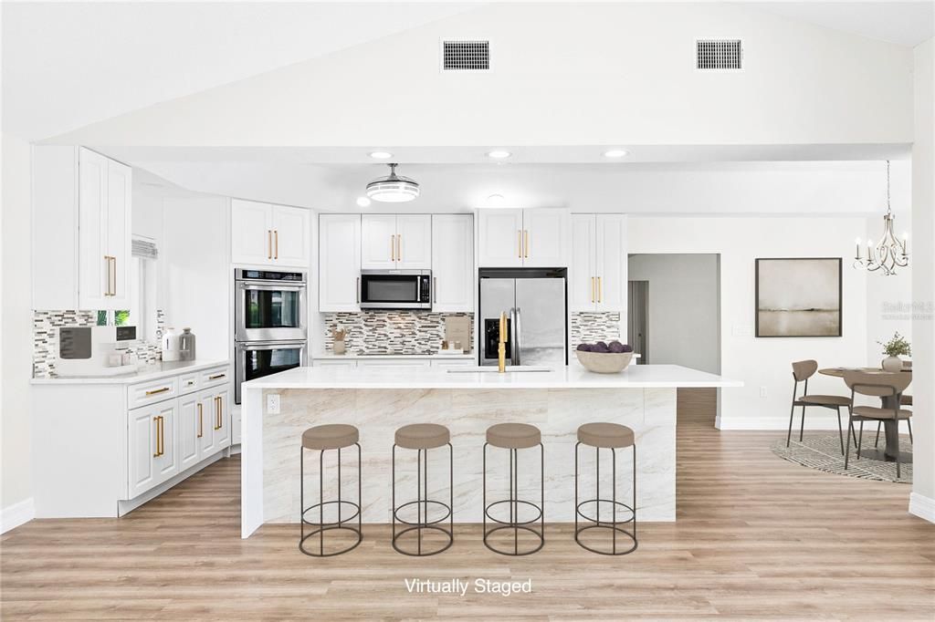 Kitchen with breakfast bar and dinette. (Virtually Staged)