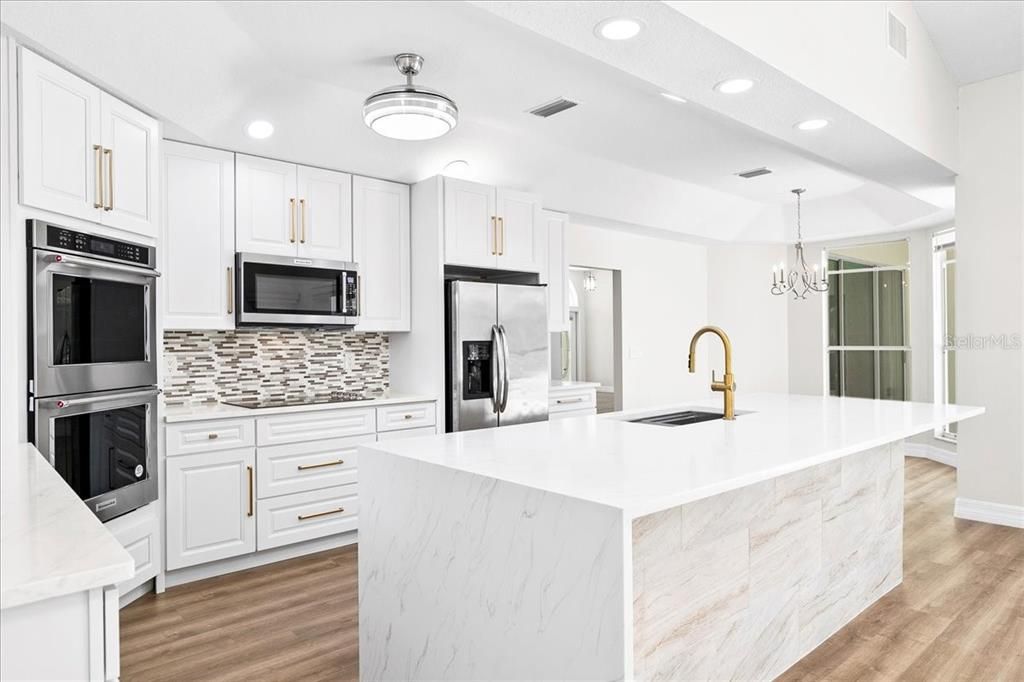 New remodeled kitchen with built-in double oven, cook top and quartz center island with waterall edge and breakfast bar for quick meals.