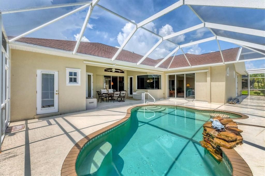 VIEW OF COVERED LANAI FROM REAR OF CAGE WITH SO MANY WAYS TO ACCESS FROM HOME -  FAR LEFT DOOR IS POOL BATHROOM, SLIDERS FROM FAMILY ROOM, SINGLE FRENCH DOOR FROM BREAKFAST NOOK, TRIPLE SLIDER FROM LIVING ROOM AND FRENCH DOORS FROM MASTER - NEVER HAVE TO TRACK THROUGH THE WHOLE HOUSE WITH A WET BATHING SUIT!!